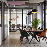 Round felt ceiling rafts in pink and natural tones hanging above a dining table in a glazed office breakout area