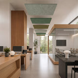 A row of square felt ceiling rafts in pale grey and green hanging above a bright open-plan office