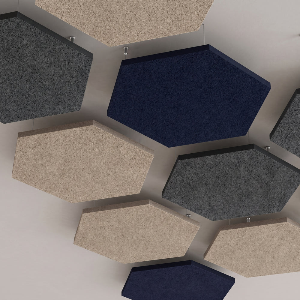 Looking up at hexagon felt ceiling rafts in navy, grey and natural, hung close together