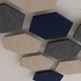 Looking up at hexagon felt ceiling rafts in navy, grey and natural, hung close together