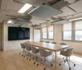 Grey square felt ceiling rafts hanging below an exposed services ceiling above a meeting table