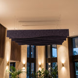 Drape felt ceiling baffles in Purple Grape in a tall, warmly lit lobby