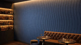 Drift engraved felt wall panels in Steel Blue, behind a bar