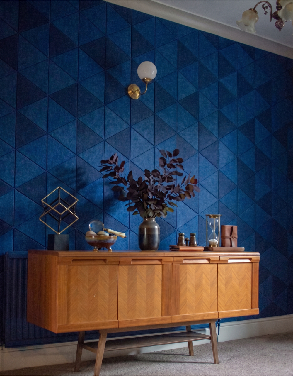 Equilateral triangle acoustic PET felt tiles arranged as a geometric feature wall in a styled room