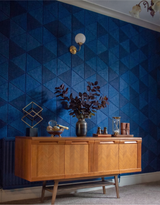 Equilateral triangle acoustic PET felt tiles arranged as a geometric feature wall in a styled room
