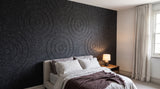Orbit engraved felt wall panels in Paynes Grey, behind a bed