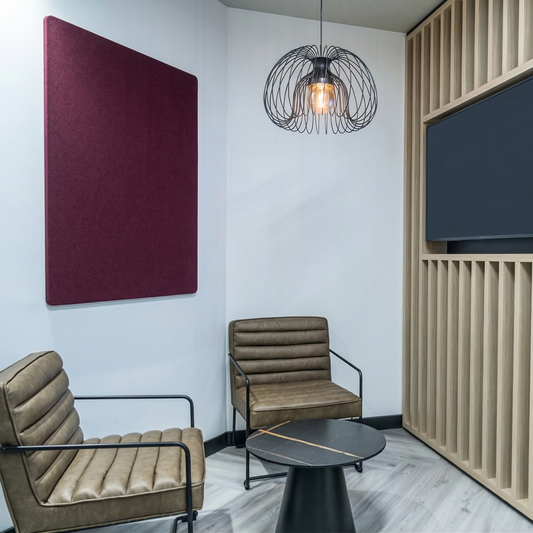 Modern office space with two chairs, a table, and a wall-mounted screen.