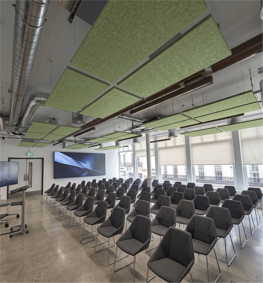 Rows of tea green rectangular felt ceiling rafts hanging above a lecture hall