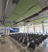 Rows of tea green rectangular felt ceiling rafts hanging above a lecture hall